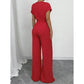 Elegáns aszimmetrikus nyakkivágású pöttyös jumpsuit